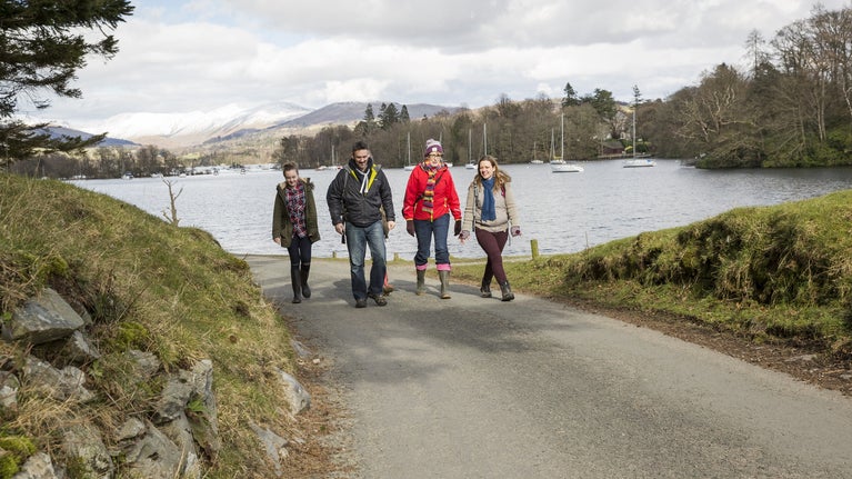 Four visitors walking along the shore of Windermere in the winter time